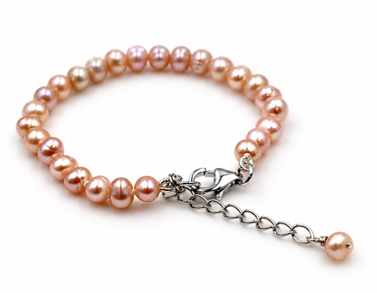 Pink freshwater cultured pearl baby bracelet with sterling silver lobster clasp and pearl-tipped extender chain on a white background.