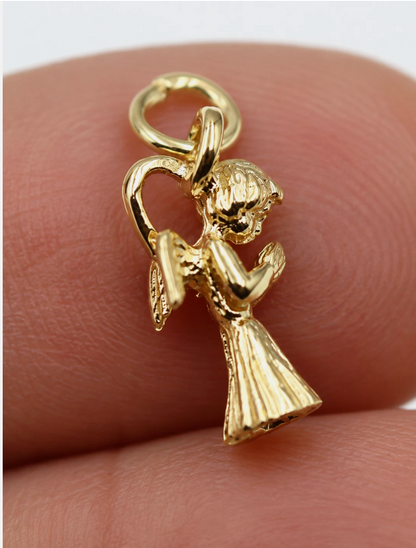 Close-up scale view of tiny genuine 9ct yellow gold praying angel charm pendant